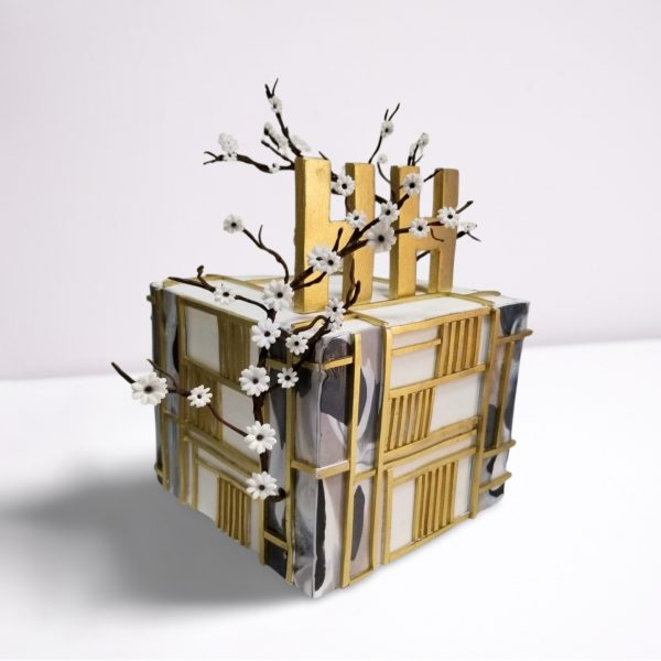 Gold and White Cube-Shaped Cake with Custom Name and Flowers